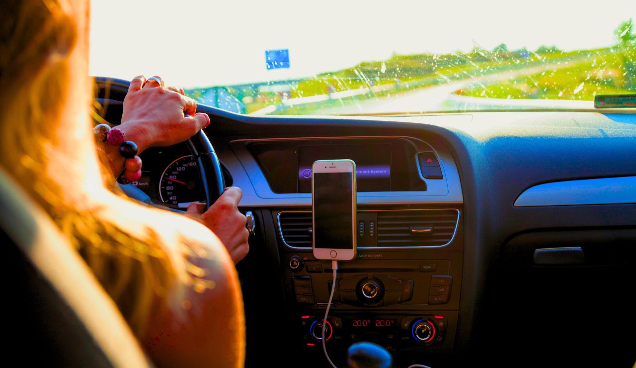 Person driving an RV on an open scenic road, hands on the wheel
