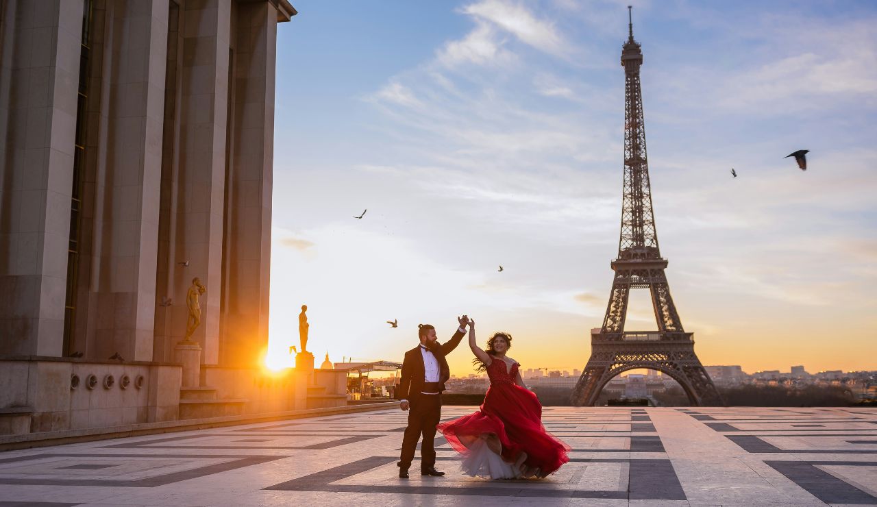 Eiffel Tower at sunset with a couple standing nearby.