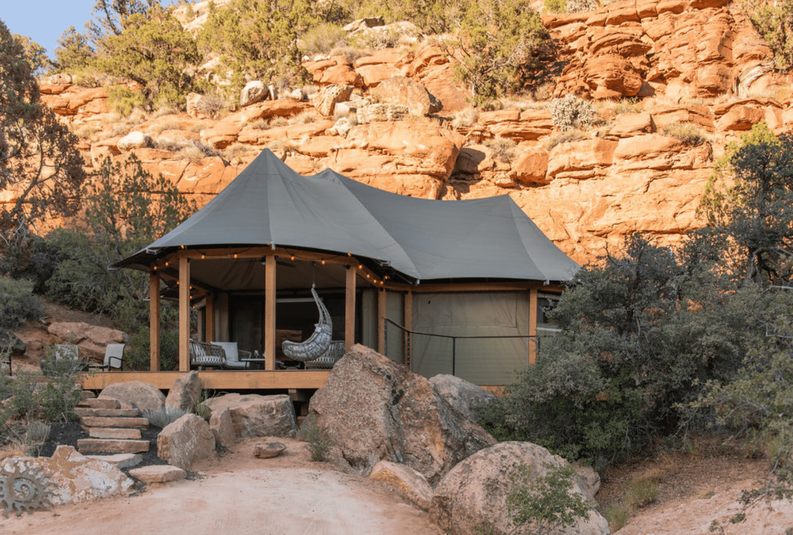 One of the glamping cabins at Open Sky Zion in front of  red rocks.