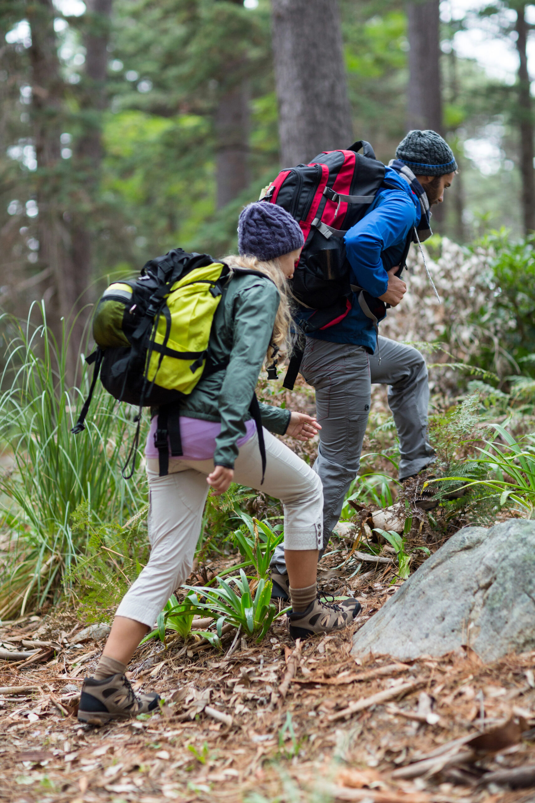 Couple hiking in the woods with backpacks and gear.