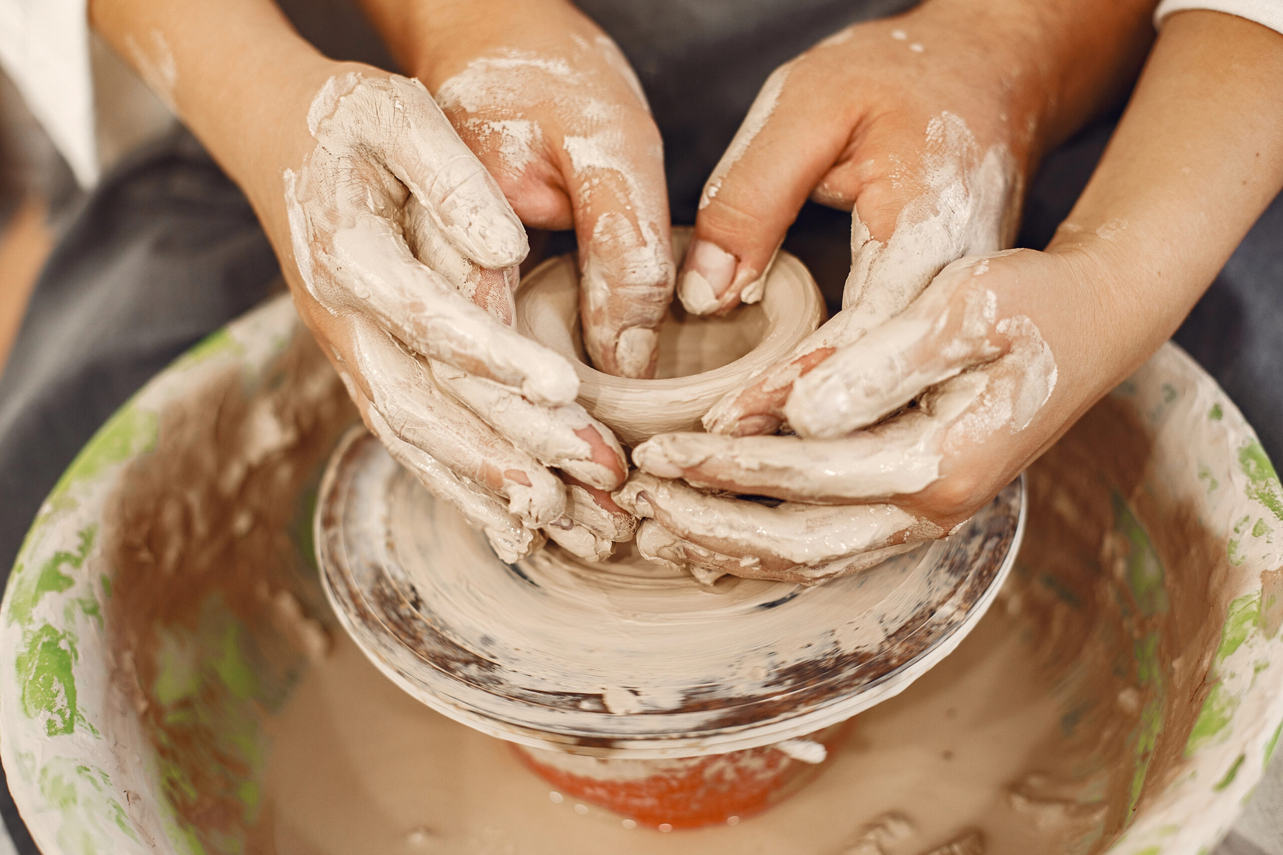 A couple's hands doing pottery together at The Art House in St. Augustine. Try it out for your St. Augustine romantic getaway!