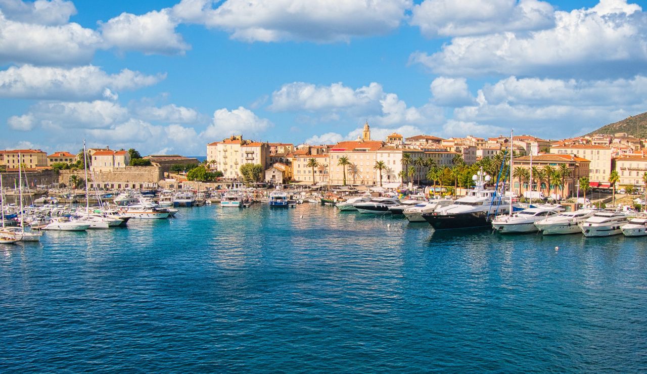 Harbor in Ajaccio, Corsica, with yachts and boats docked along the waterfront.