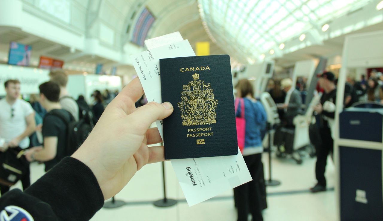 Printed boarding pass and transit visa documents on suitcase at airport check-in.