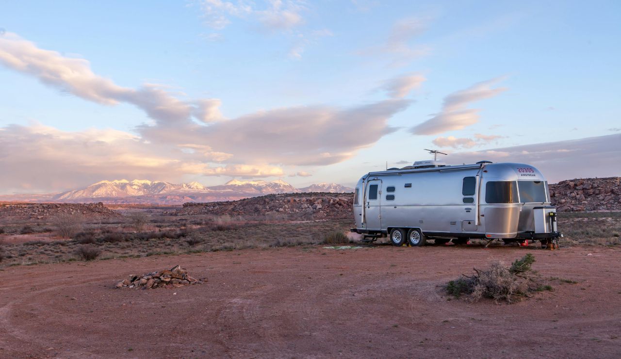 RV overlooking Sand Hollow reservoir with red rocks.