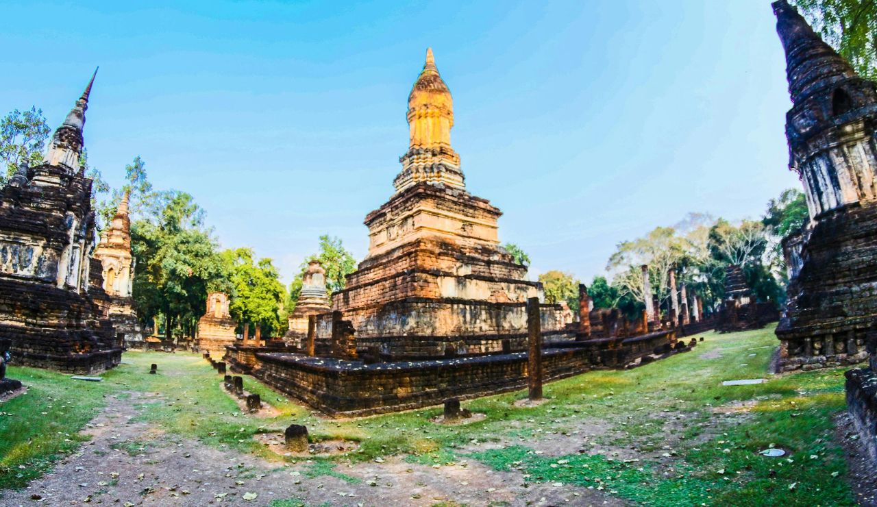 Cyclists exploring ancient temple ruins in Sukhothai Historical Park