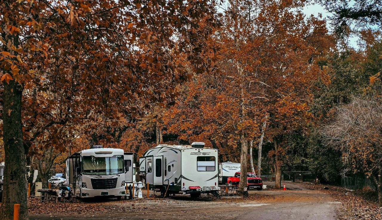 RV shaded under tall cottonwood trees in Hurricane, Utah.