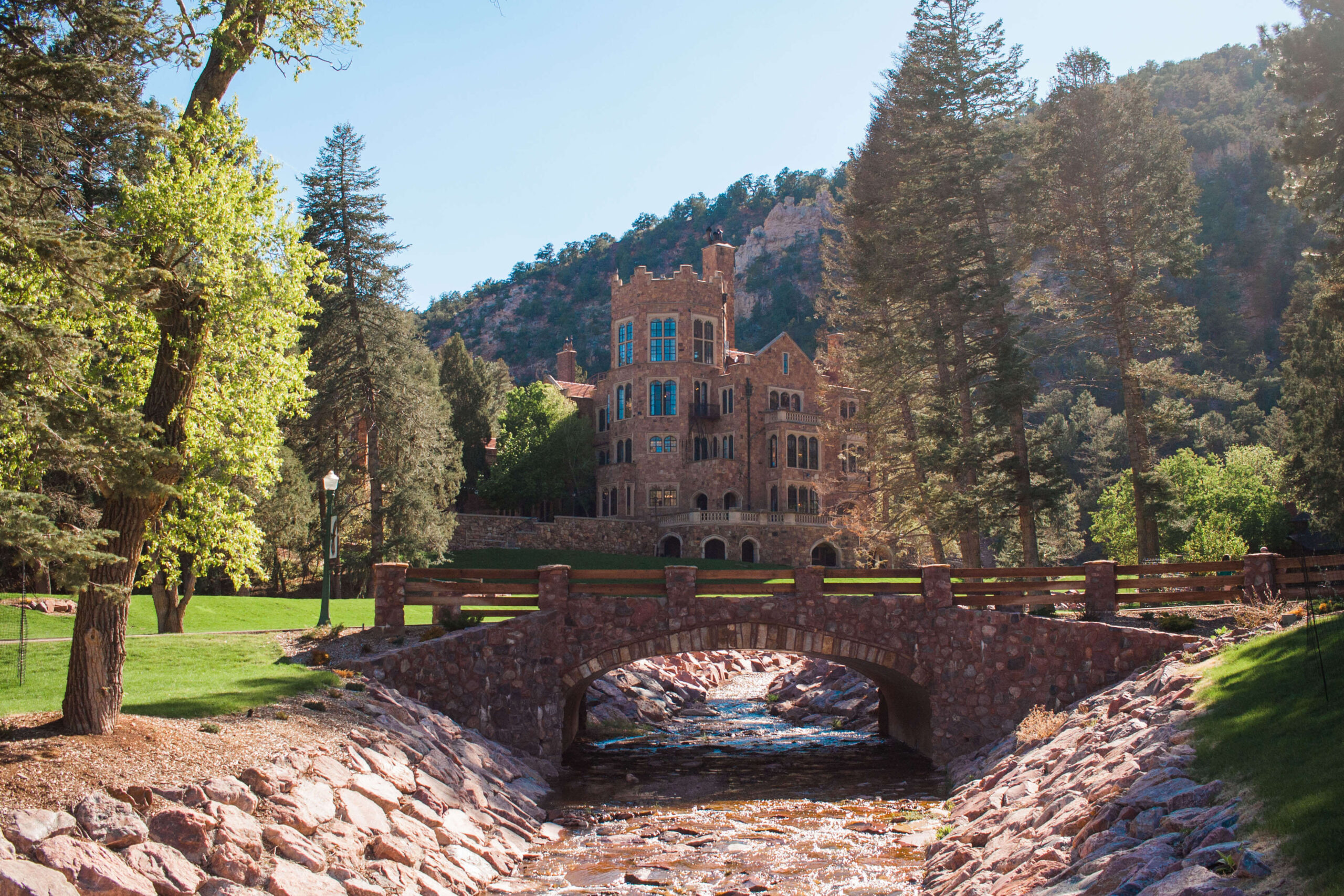 A stone bridge spans a stream before Glen Eyrie Castle, one of the most romantic getaways in Colorado Spings.