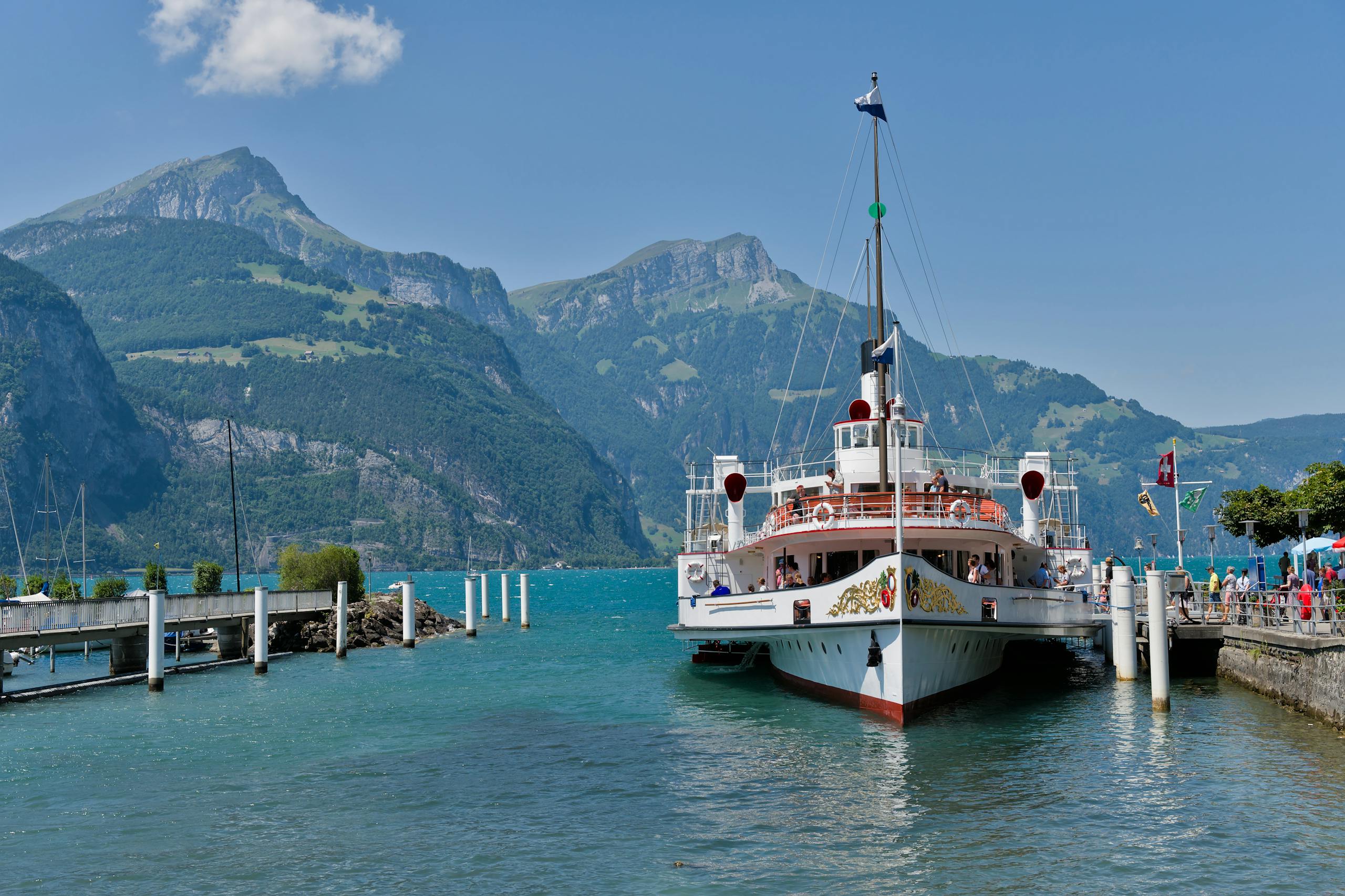 A picturesque steamboat docked at Lake Lucerne, surrounded by stunning Swiss Alps scenery.