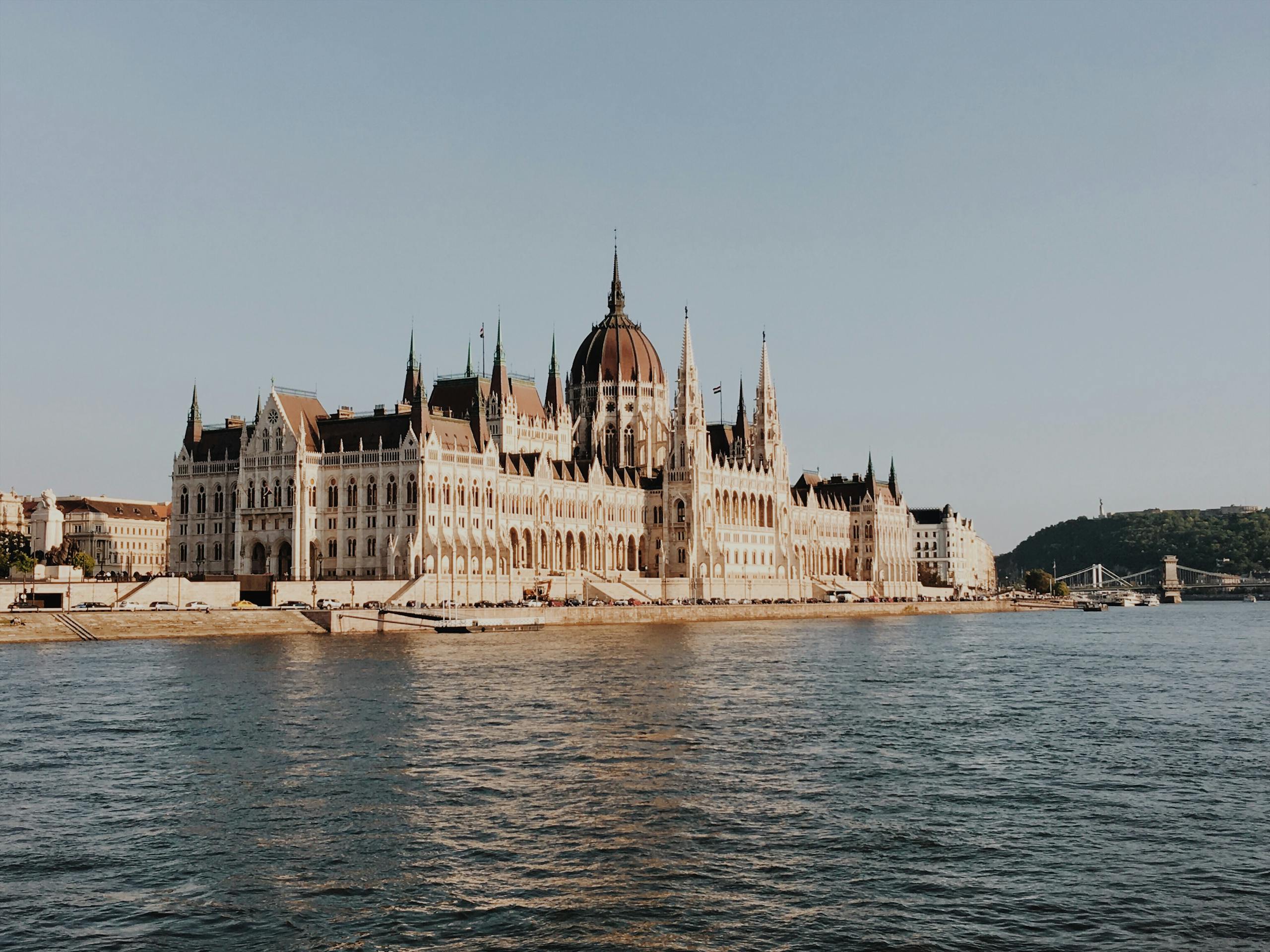 Stunning view of the Hungarian Parliament Building along the Danube River in Budapest during the day.