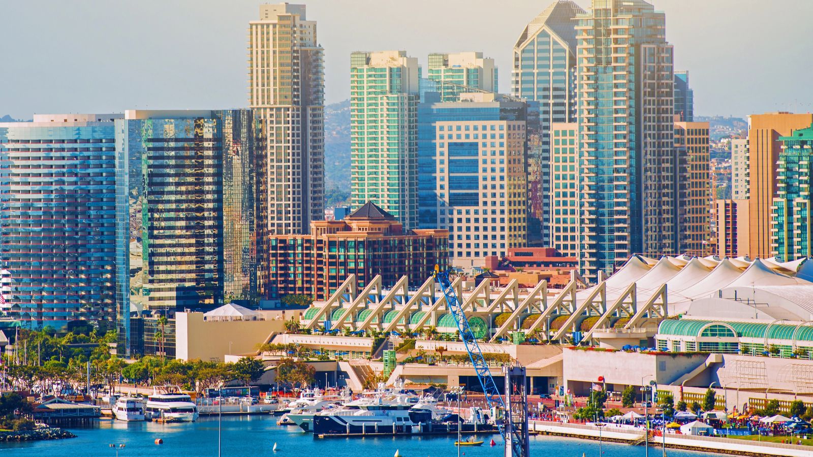 San Diego skyline with high-rise buildings and marina boats along the waterfront near the San Diego Convention Center.