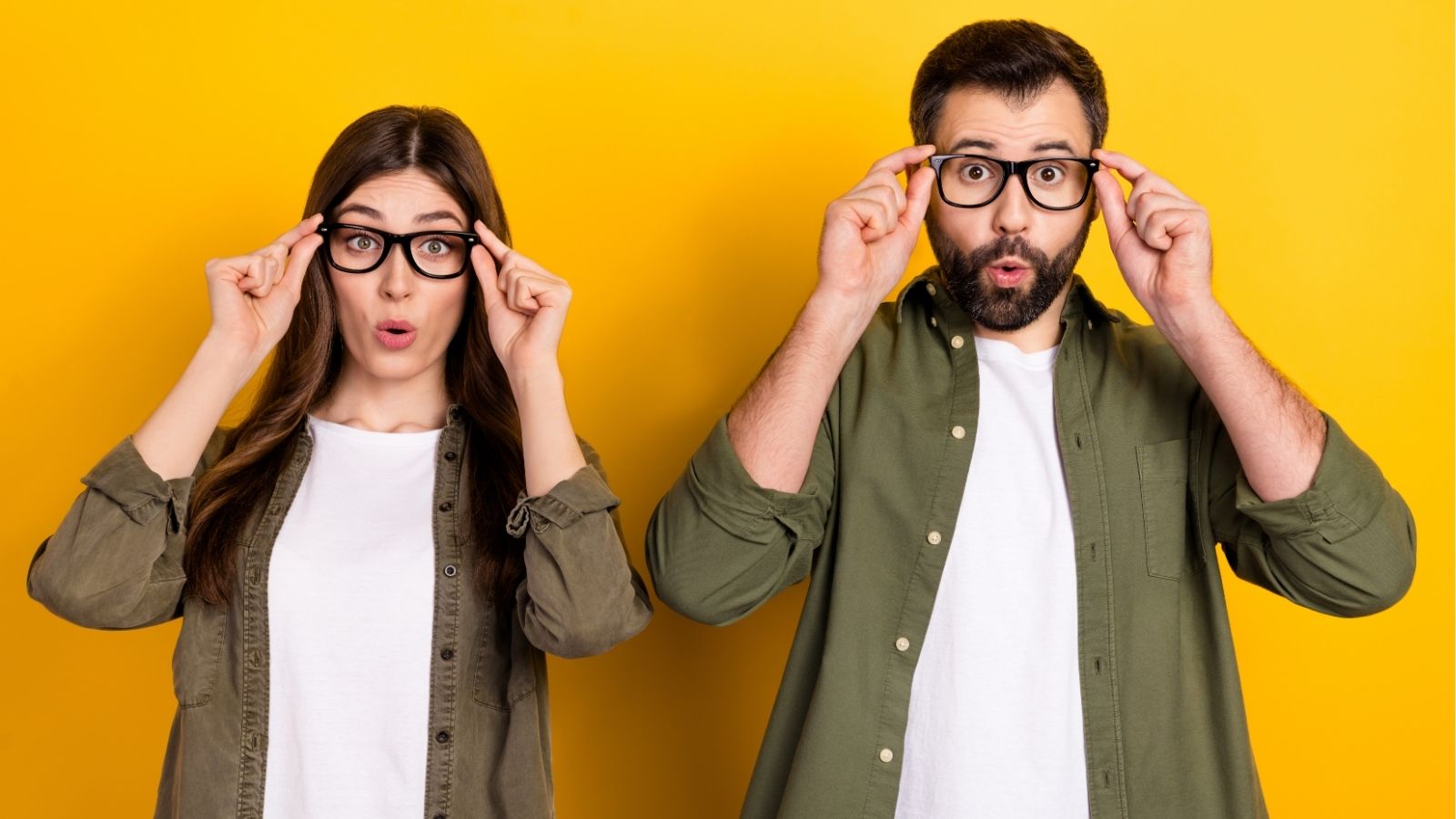 A man and a women looking surprised while adjusting their glasses.