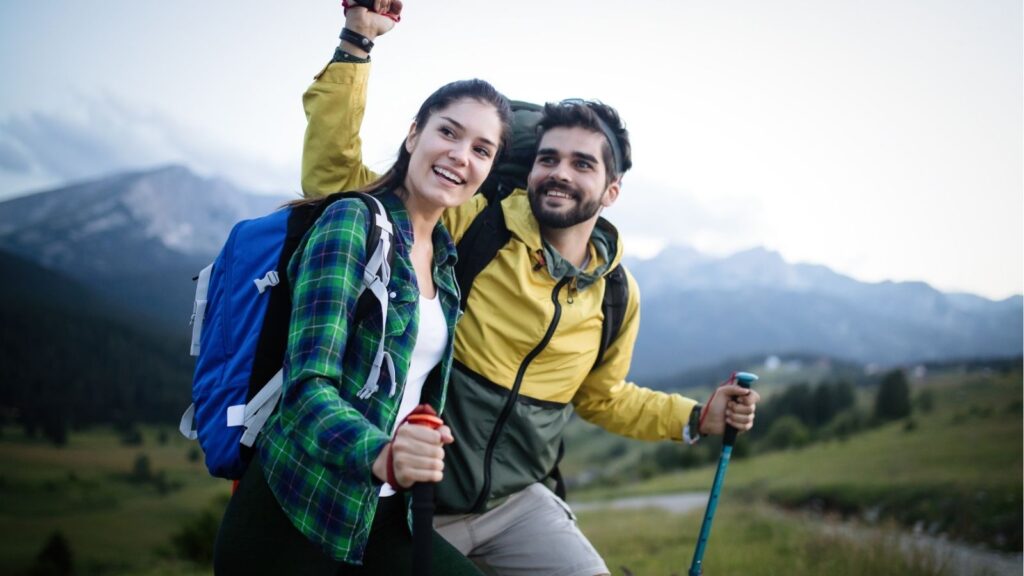 An image of a couple hiking and smiling.