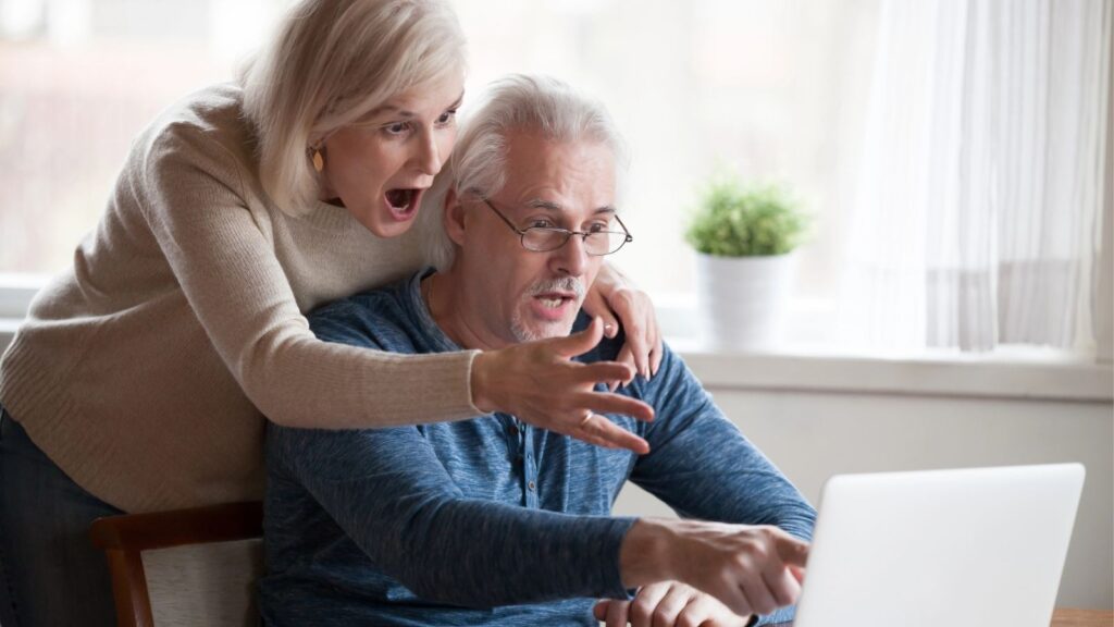 An image of two older couples looking at the laptop screen.