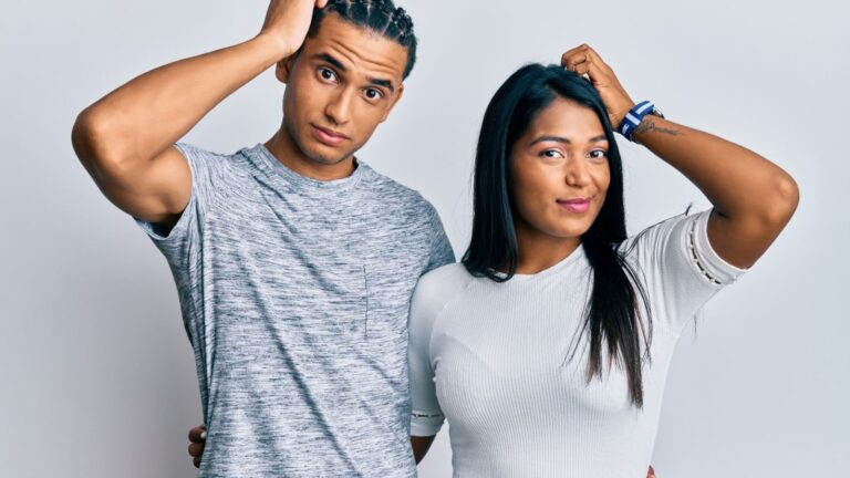 A picture of a man and a woman scratching their heads.