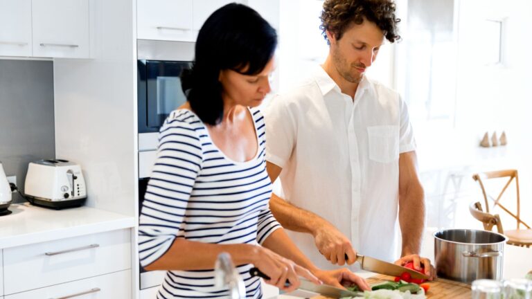 A couple cooking in a full-sized kitchen.