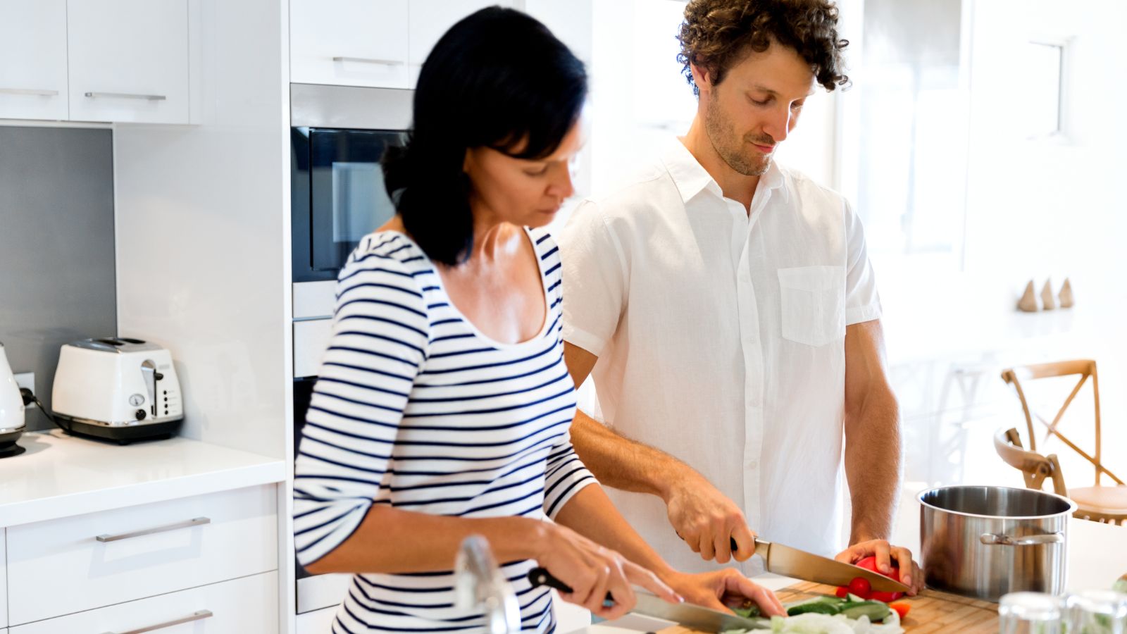 A couple cooking in a full-sized kitchen.
