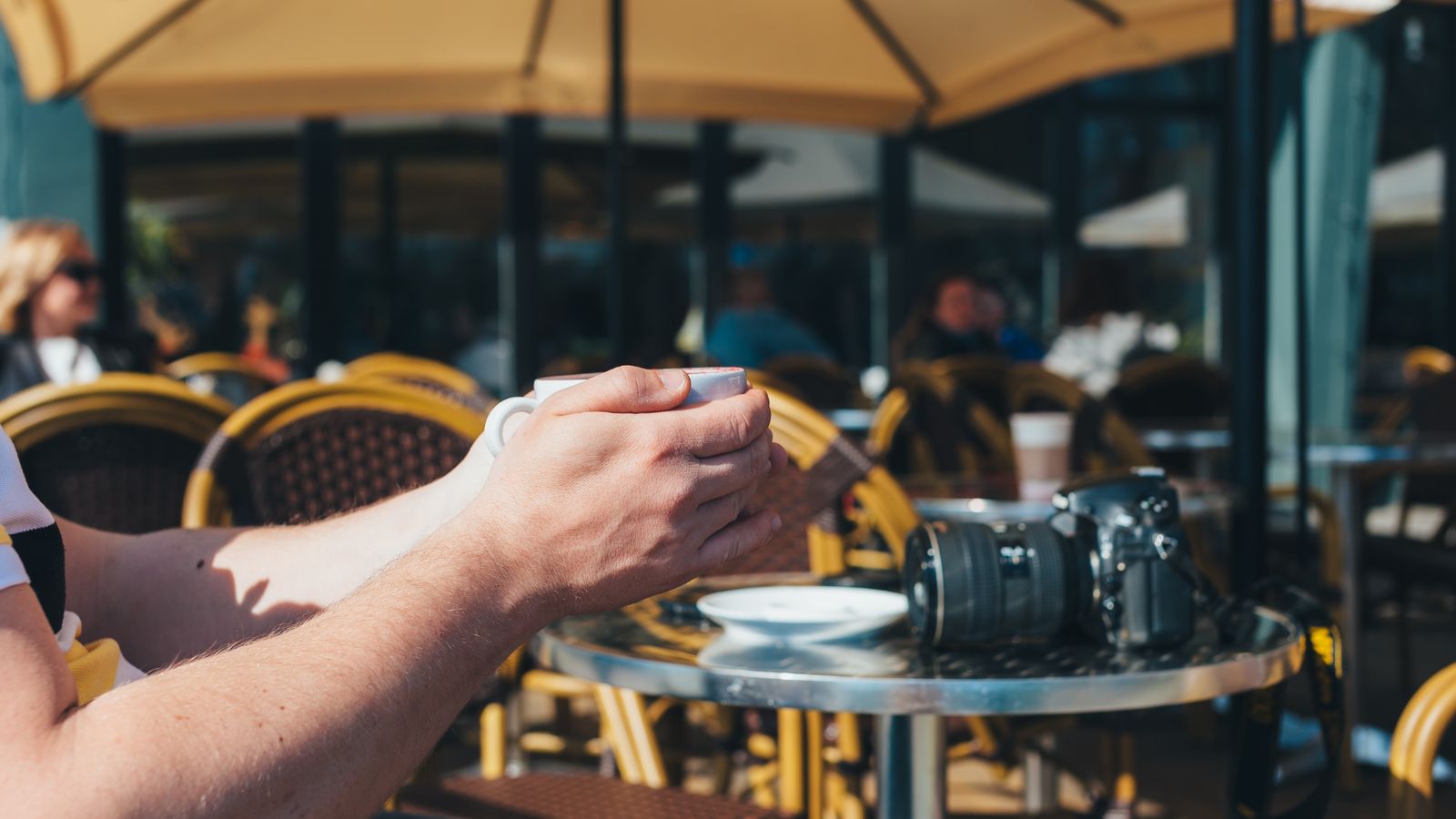 A photo of Traveler enjoying drink at outdoor café abroad.