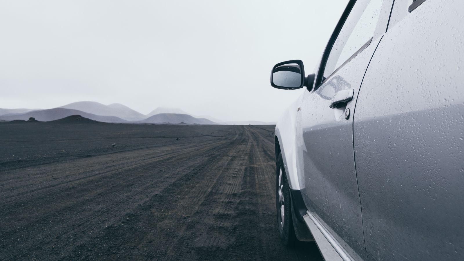 A photo of Car driving on gravel road in Iceland.