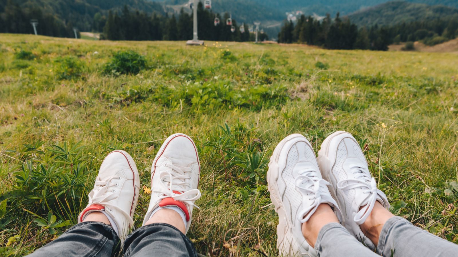 A picture of a pair of shoes laying relaxingly in the clean green grass.