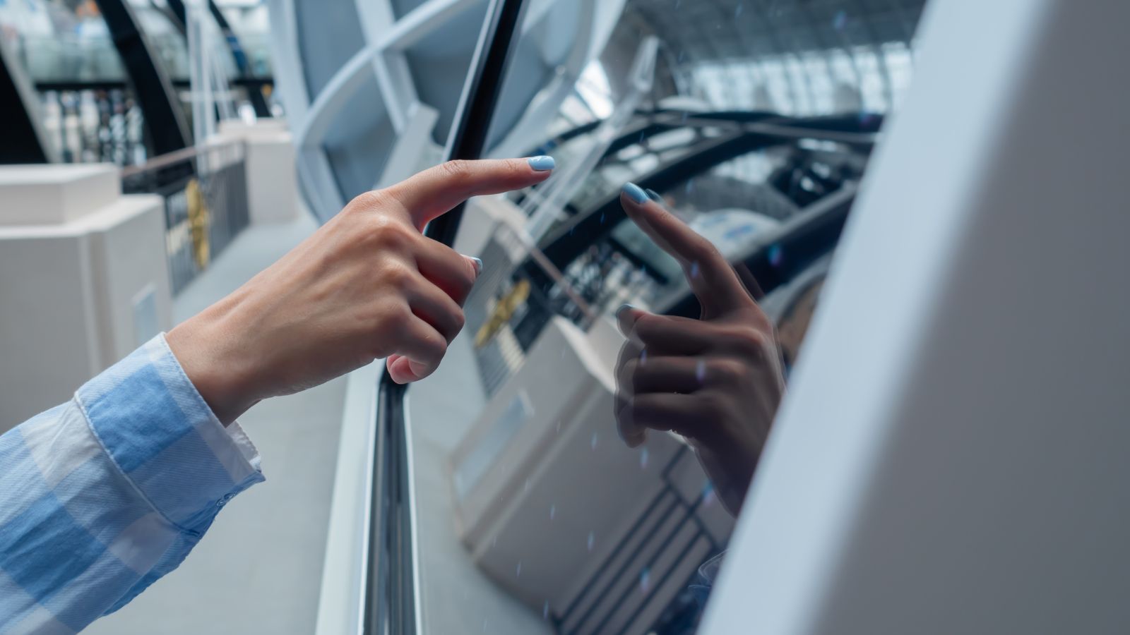 A photo of a close-up of hands touching a screen.