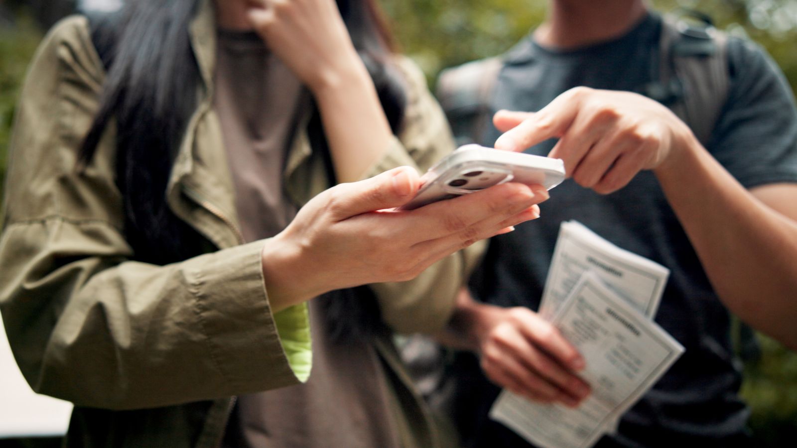 A photo of couple holding a phone and an important paper.