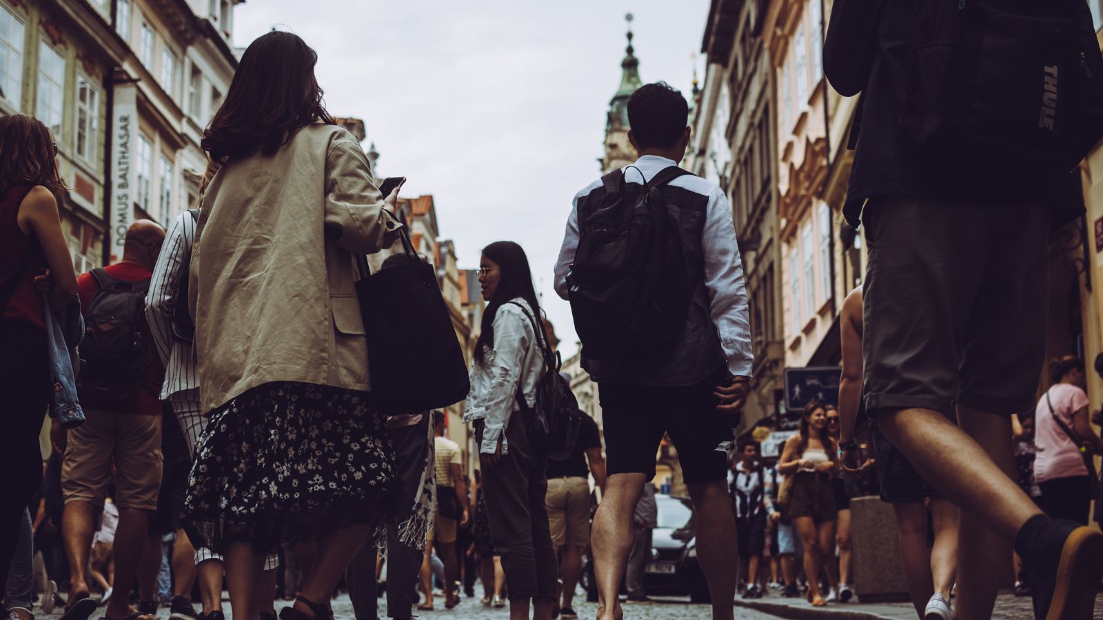 A photo of Crowded European city sidewalk with tourists and locals walking together.