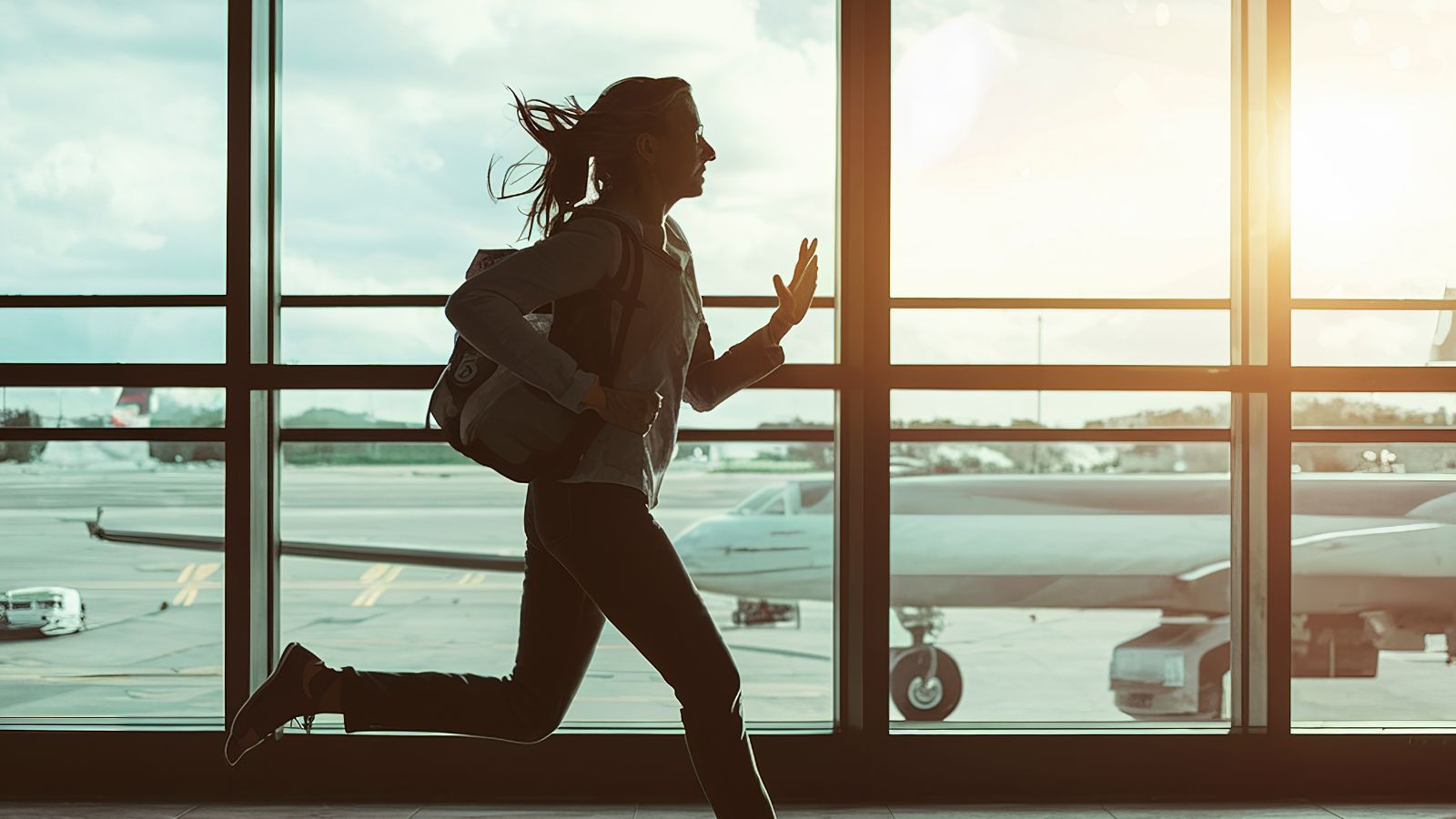 A travel girl that is running inside the airport.