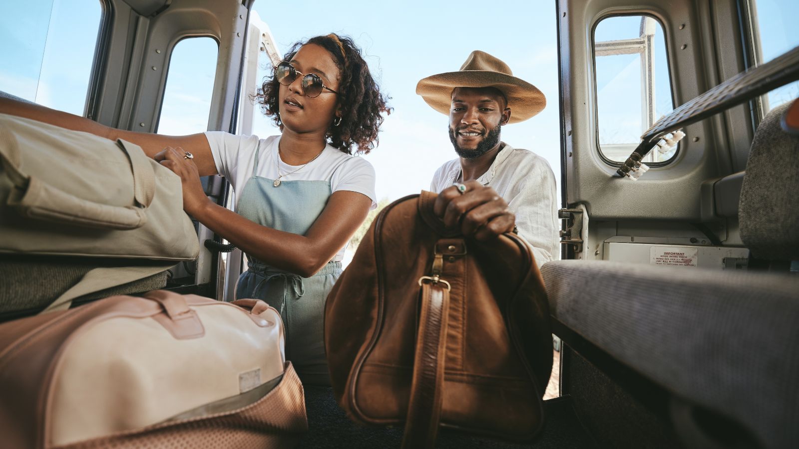 A picture of a couple helping each other put their things inside a van.