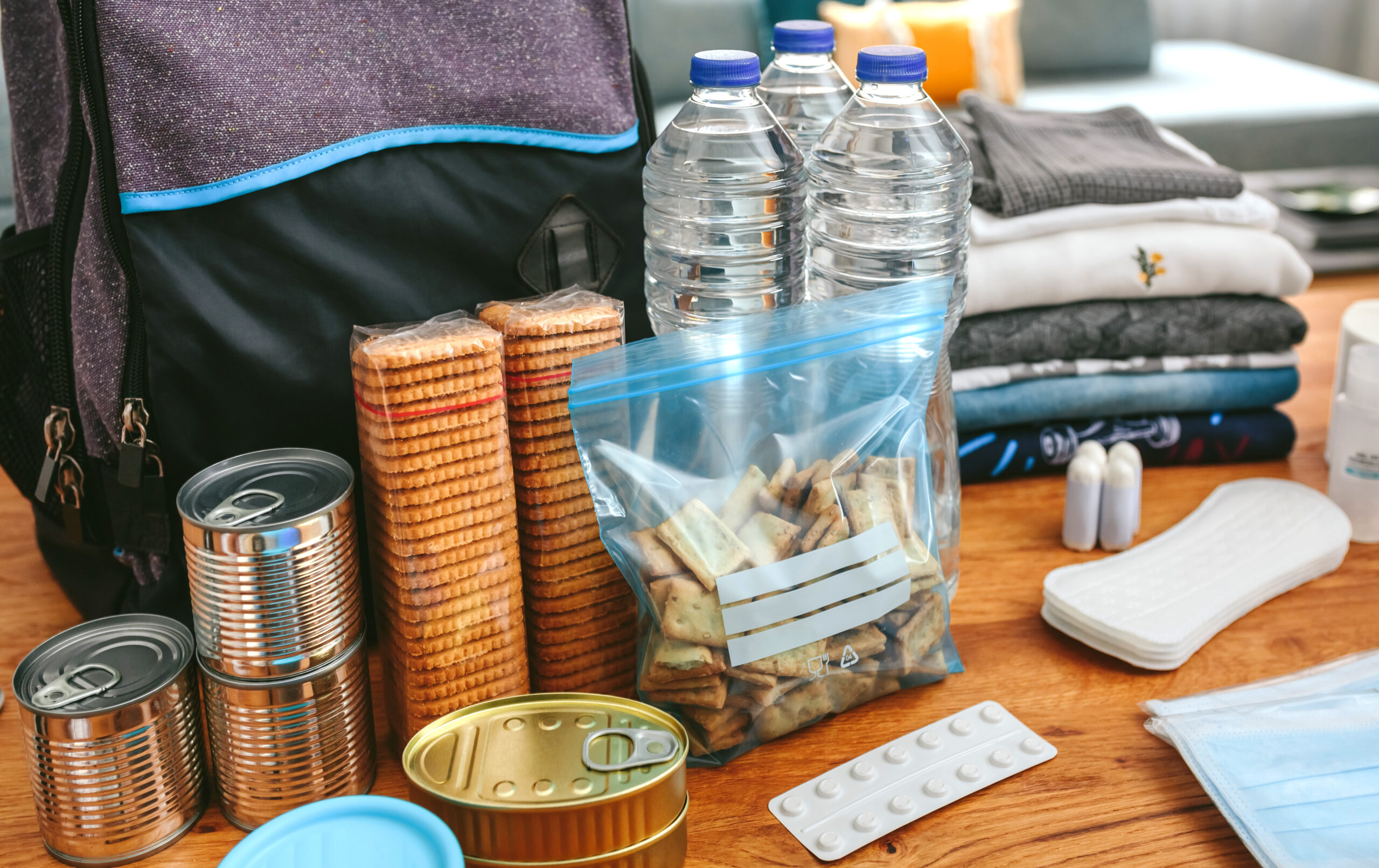 An Emergency backpack equipment organized on the table in the living room.