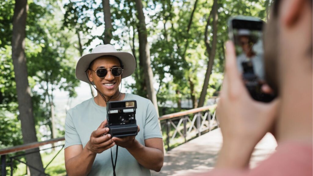 A picture of a man being photographed while holding a camera.