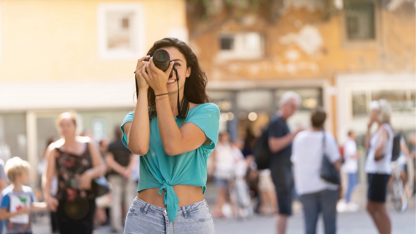 A girl holding the camera viewfinder against her eye and taking a picture.