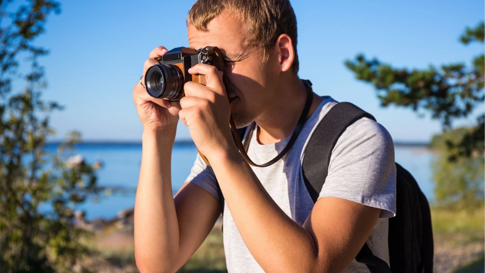 A man taking a photo with his camera and looking through the viewfinder.