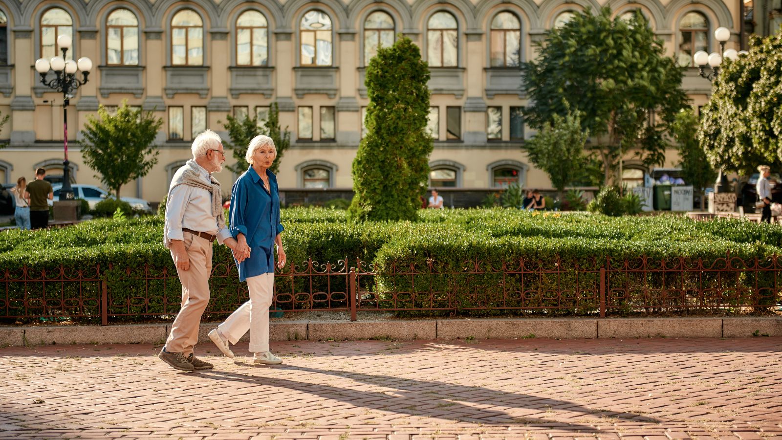 A photo of older couple walking city sidewalk relaxed.