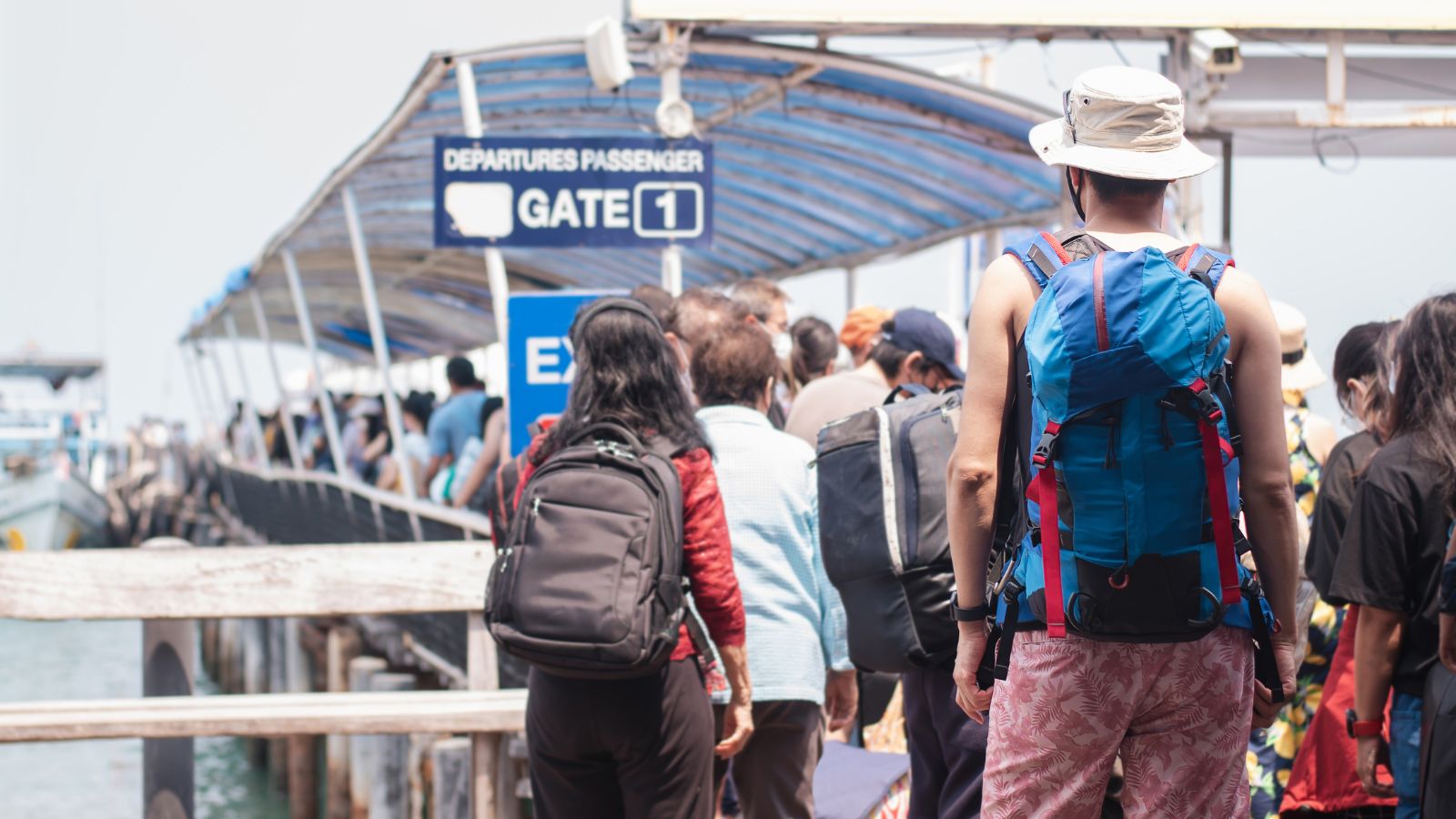 A photo of a long lign of passengers in the port.