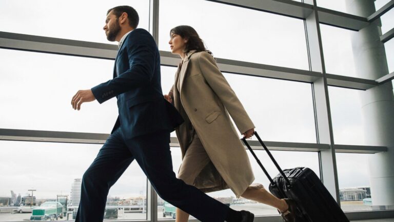 A picture of a couple in business attire in the airport.