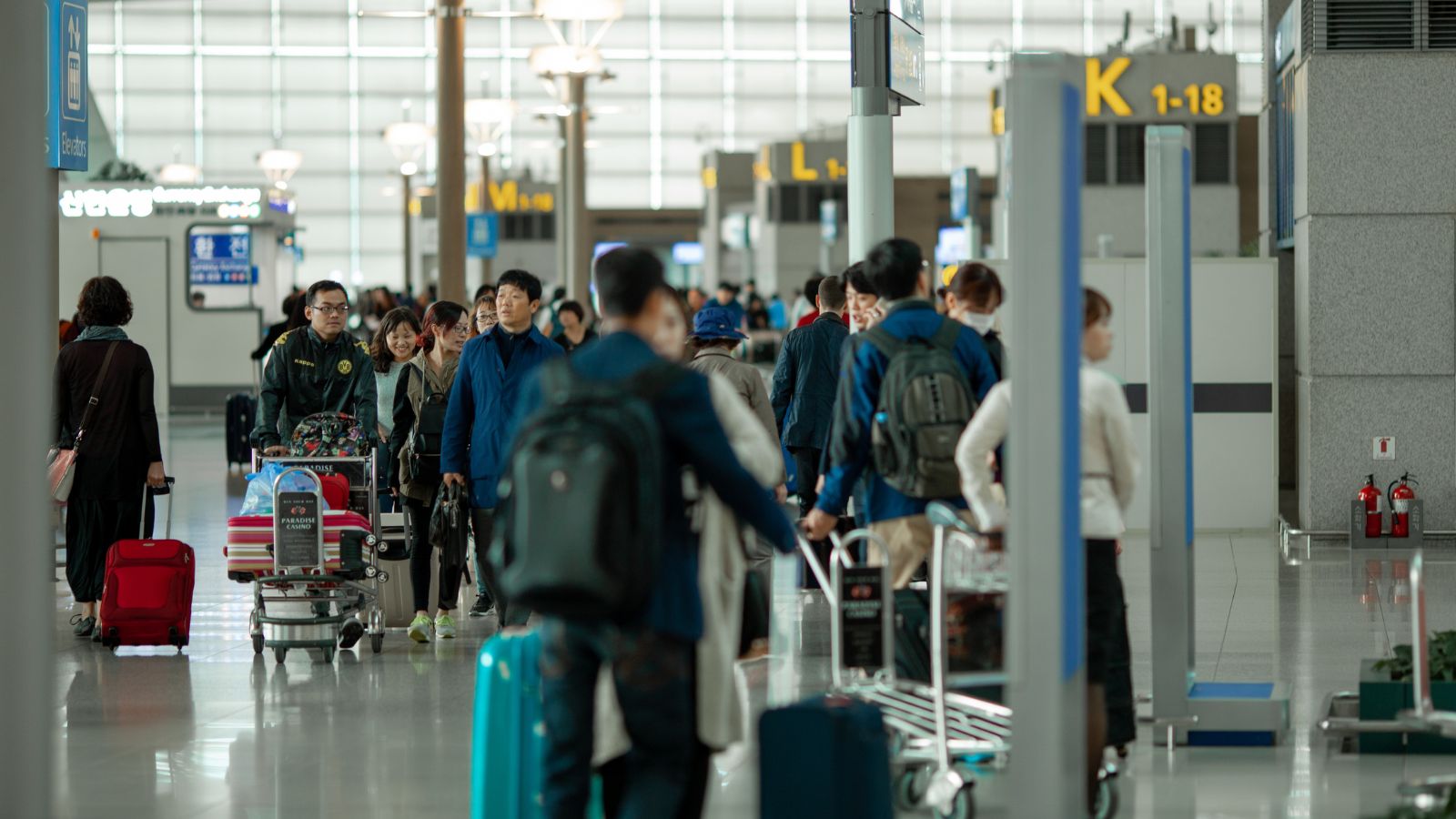 A travelers carrying their own luggage in the airport.