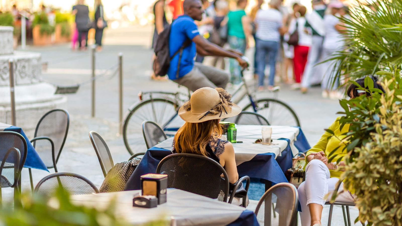 A photo of a Traveler observing city life from sidewalk café abroad.