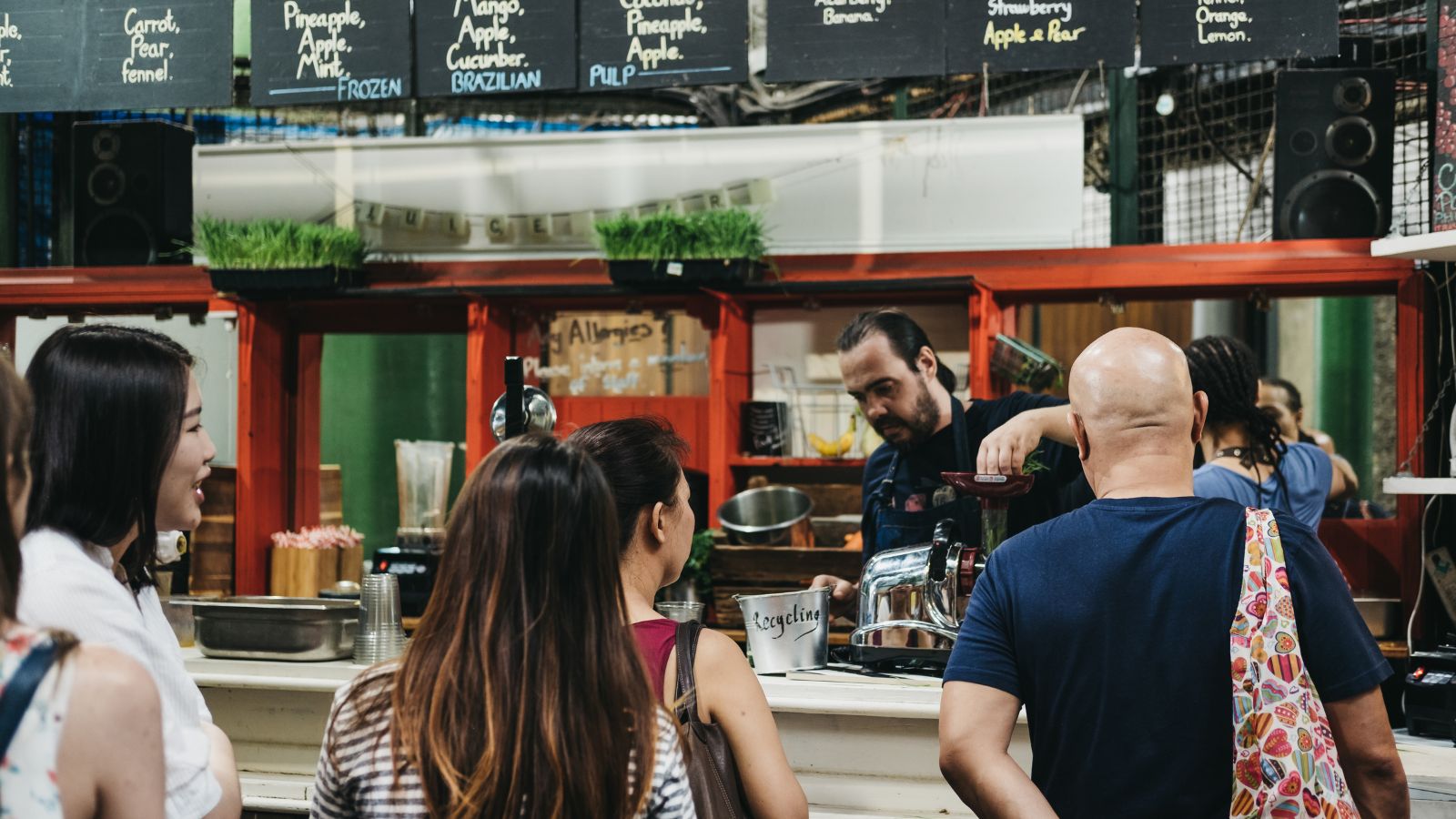 A photo of Tourist standing in line awkwardly or hesitating at a café counter.