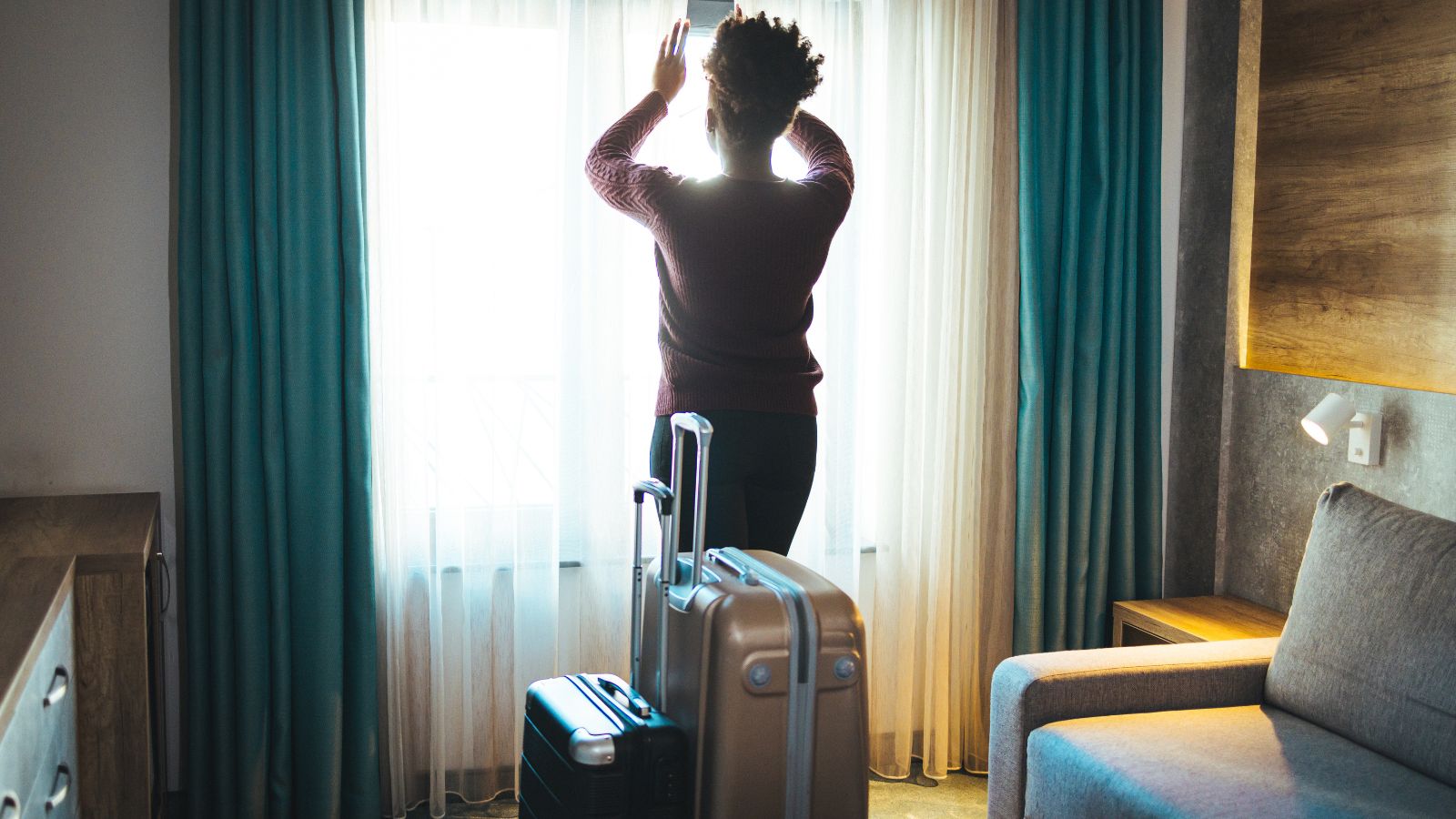 A photo of Traveler with suitcase inside small European hotel room.