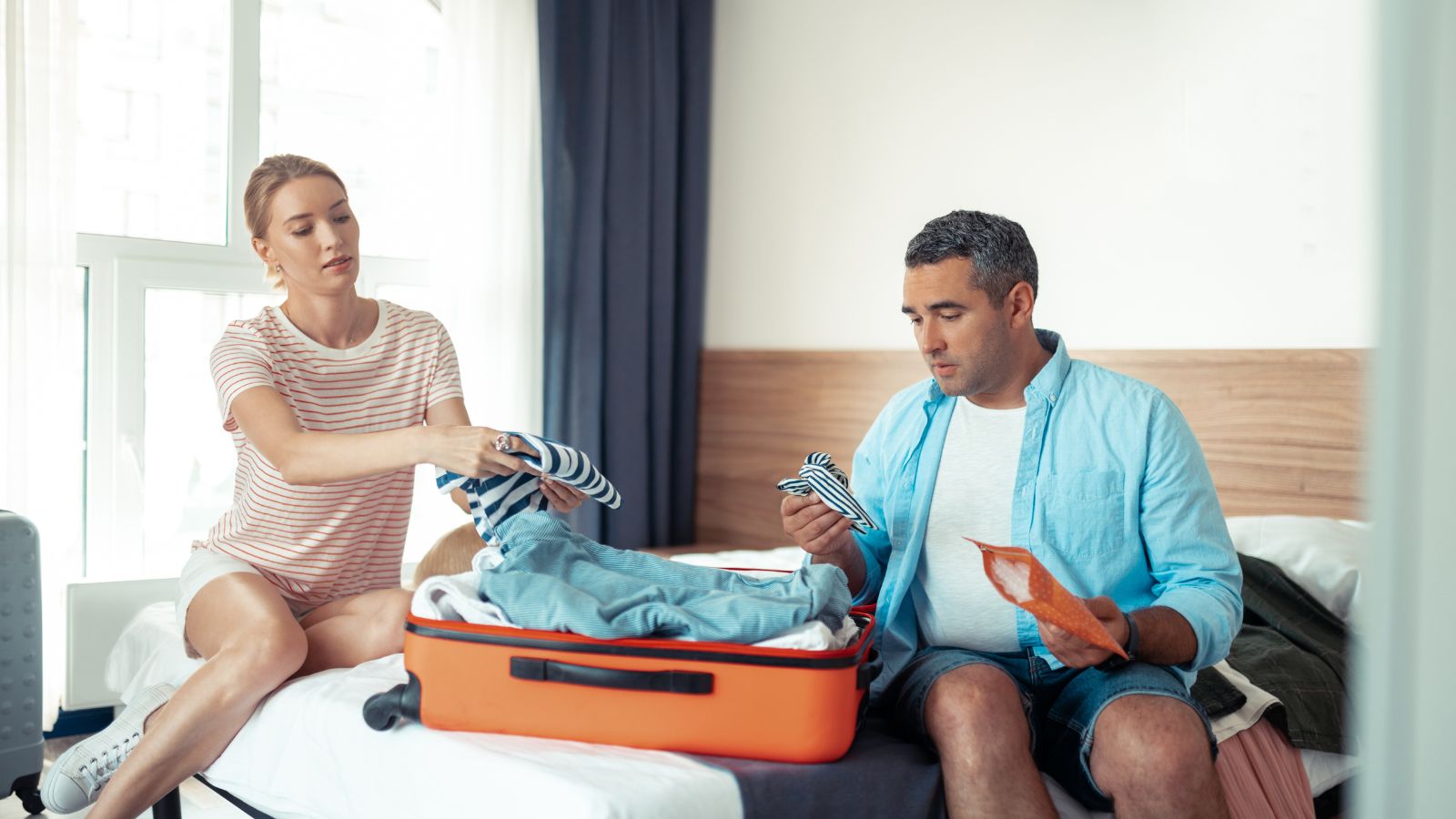 A photo of couple unpacking in the bed.