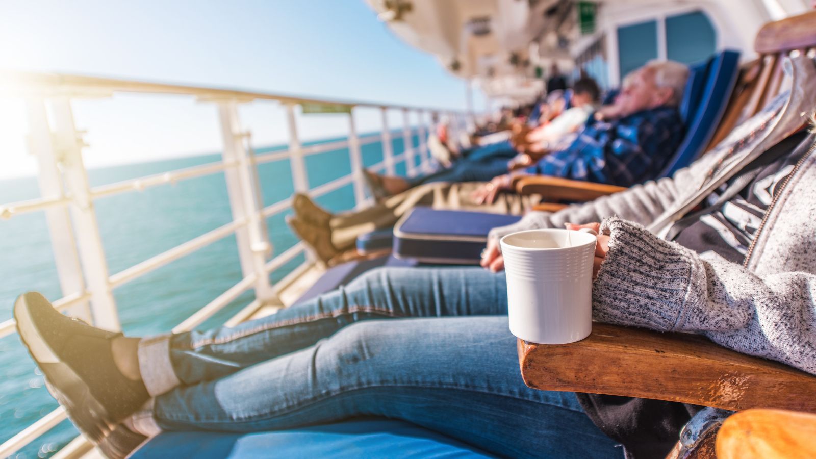 A photo of cruise passengers resting facing the ocean view.