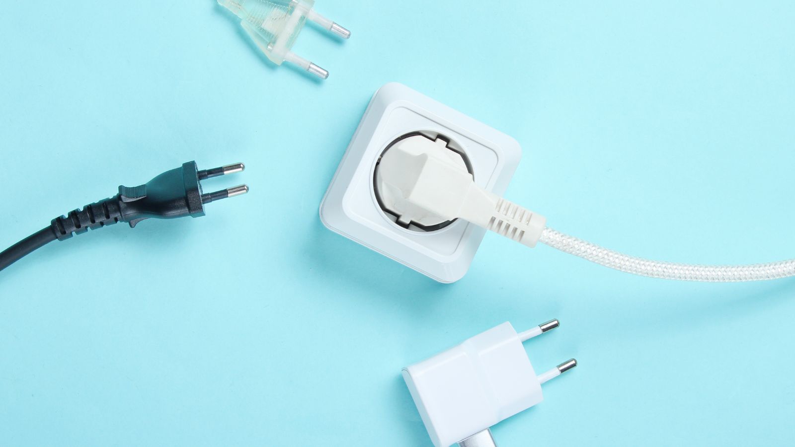 A white plug in a socket on a blue background is surrounded by three unplugged cords.