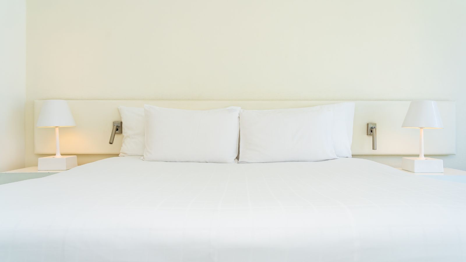A photo of a bed with matching white pillows and bed sheet.