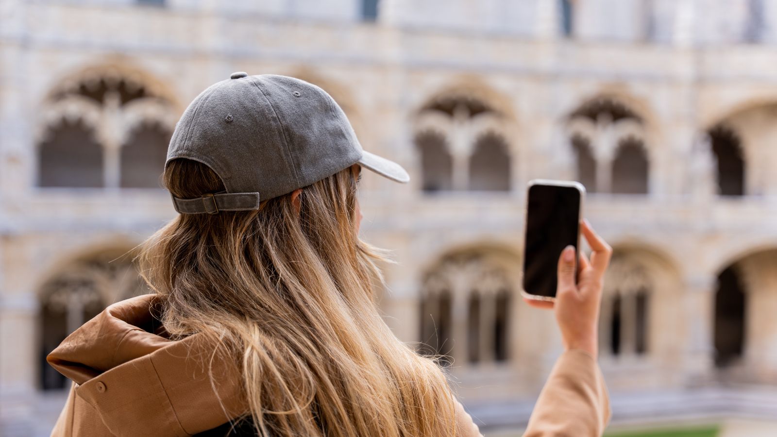 A photo of Traveler standing at a famous landmark, looking at phone.