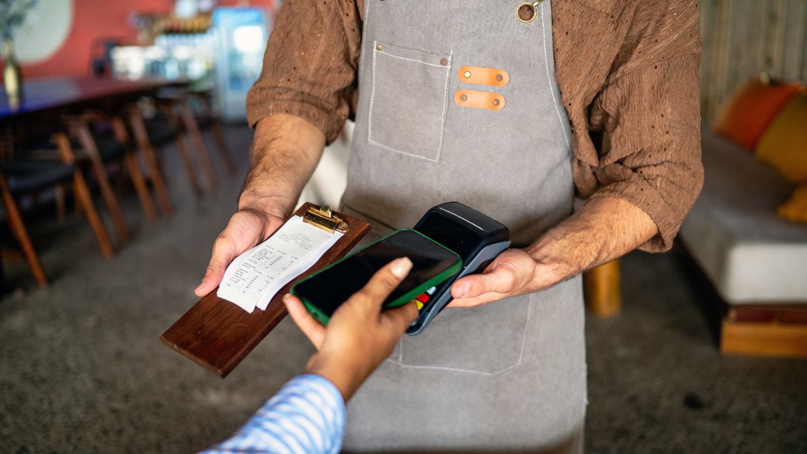 A photo of a Restaurant scenes from different countries, server receiving payment without tip.