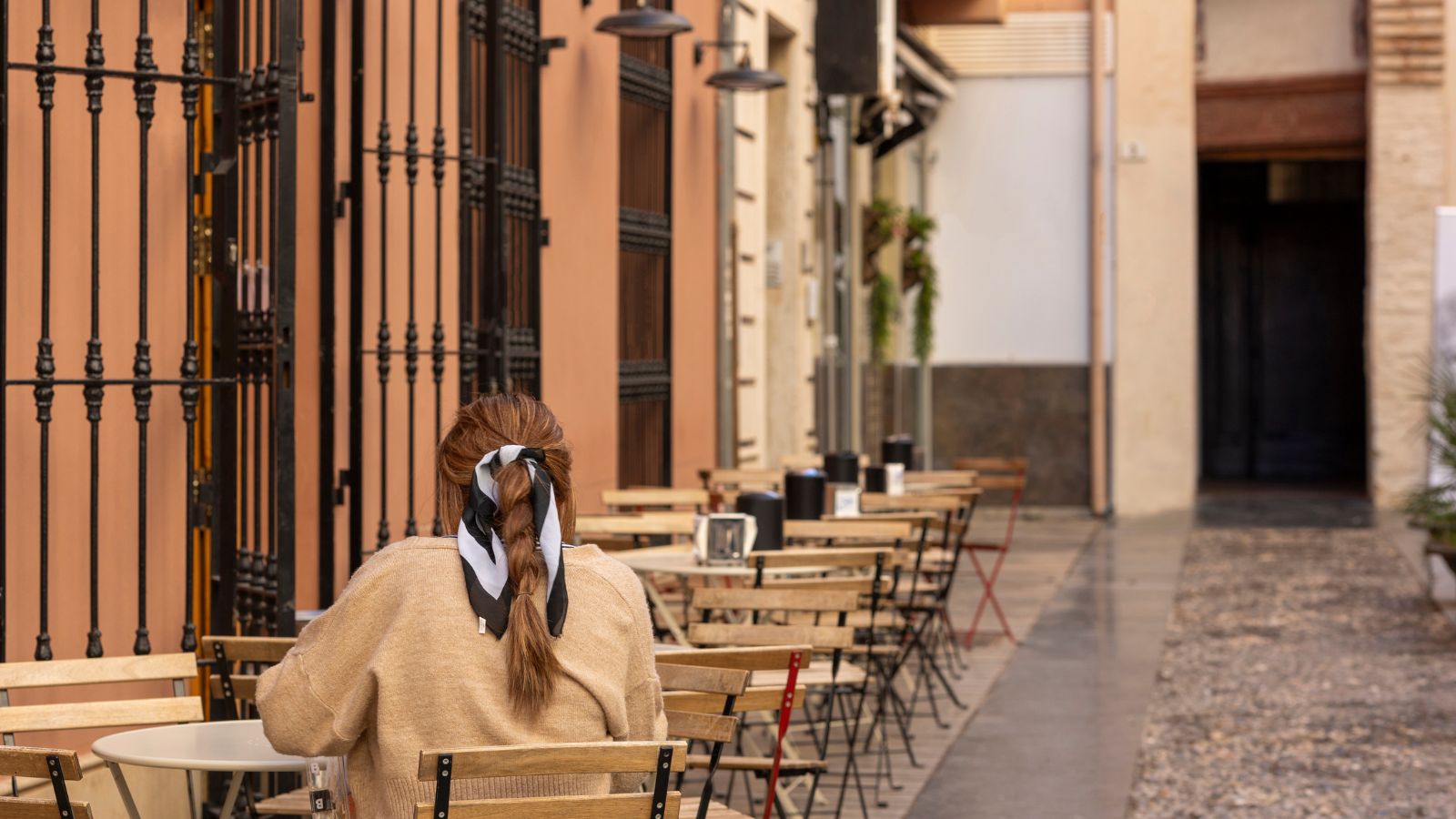 A photo of an empty tables inside, quiet street.
