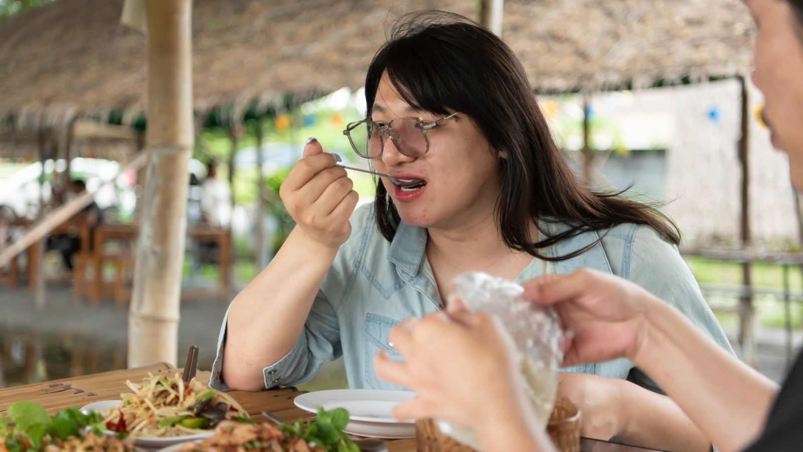 A photo of a Traveler dining at a small local restaurant, tasting unfamiliar regional dish.