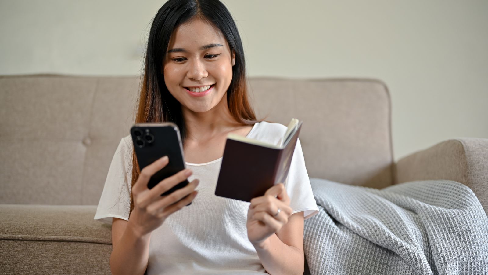A photo of a Traveler reviewing travel plans with passport and phone.