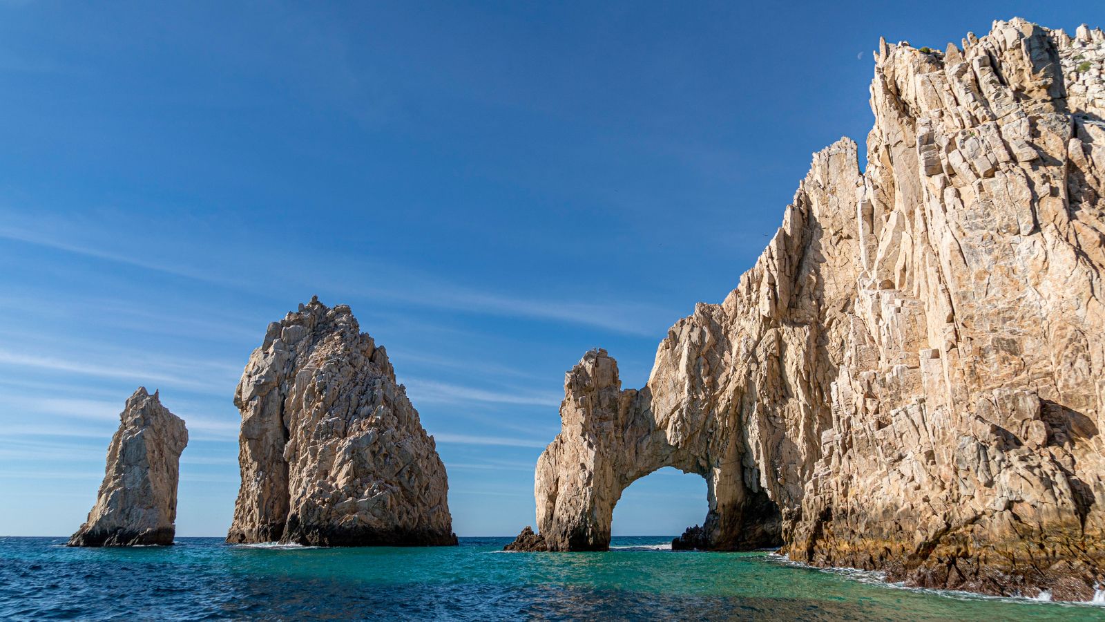 A photo of Cabo sunlit beach and resorts in the distance.