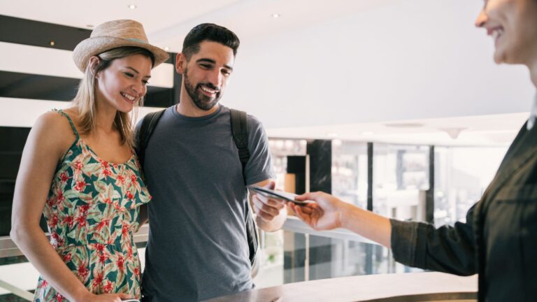 A photo of a couple facing front desk.